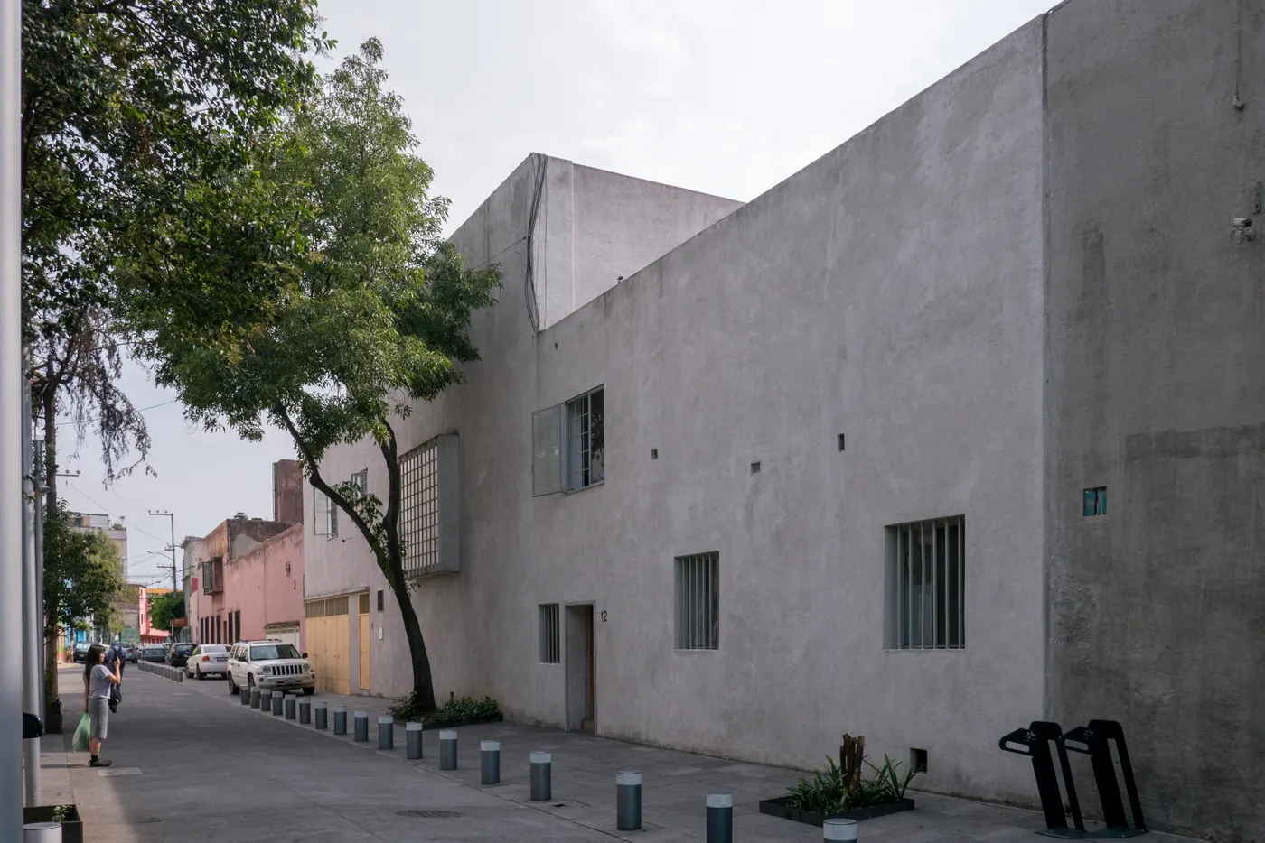 The grey street front of Casa Luis Barragán, with the grid of its translucent library window, on General Francisco Ramírez