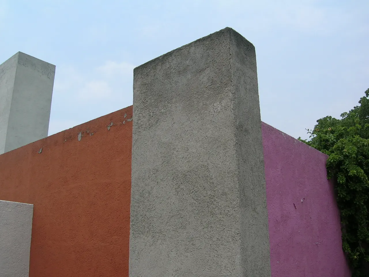 Coloured walls on the roof terrace of Casa Luis Barragán, with the white water tower rising above them